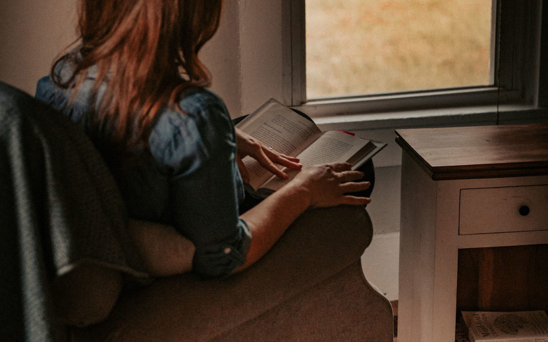 girl on a chair reading by a window