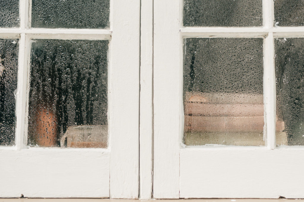 close up of kitchen window covered in raindrops