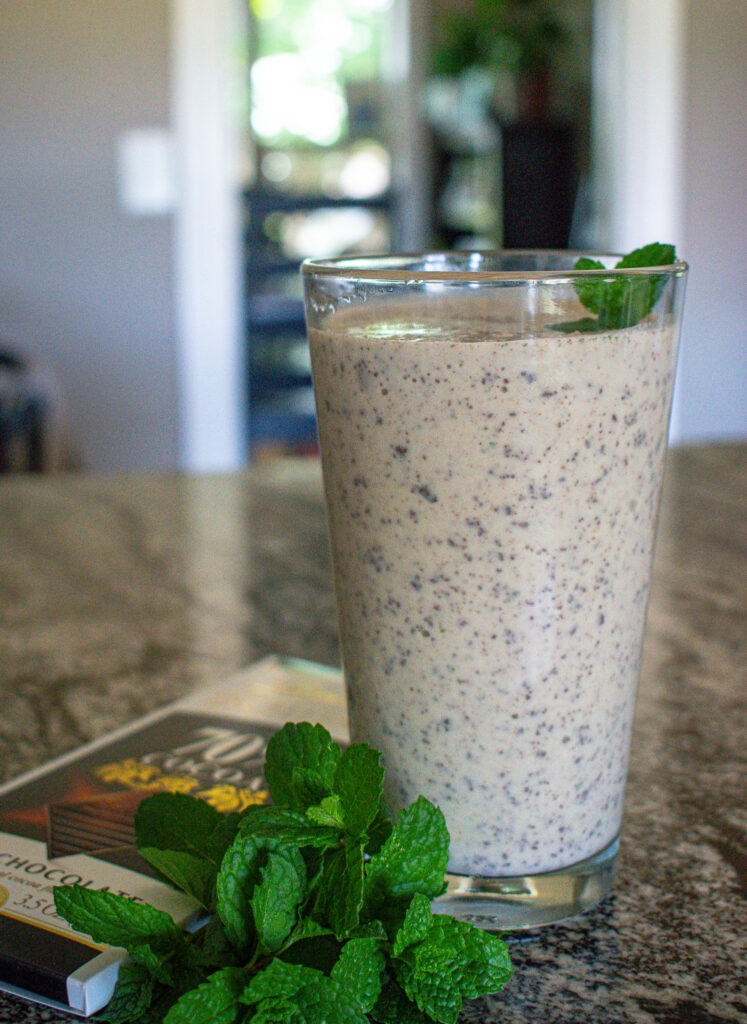 protein shake surrounded by mint leaves and chocolate