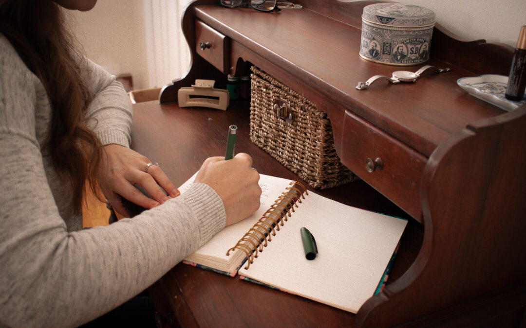 woman at desk writing in journal