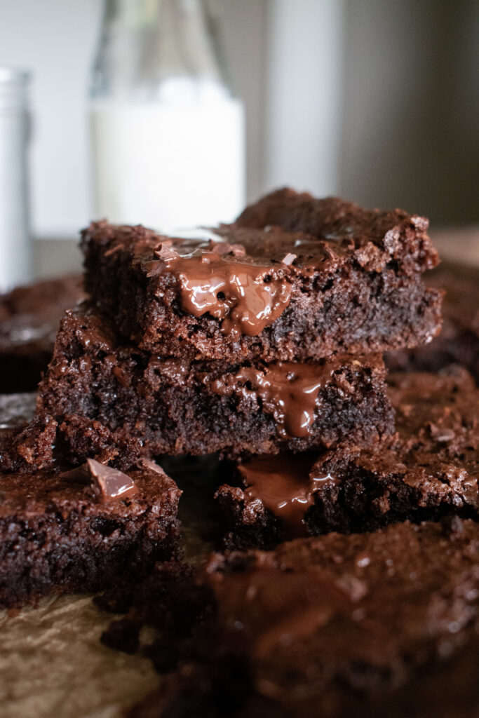 stacked gluten free brownies with milk in background