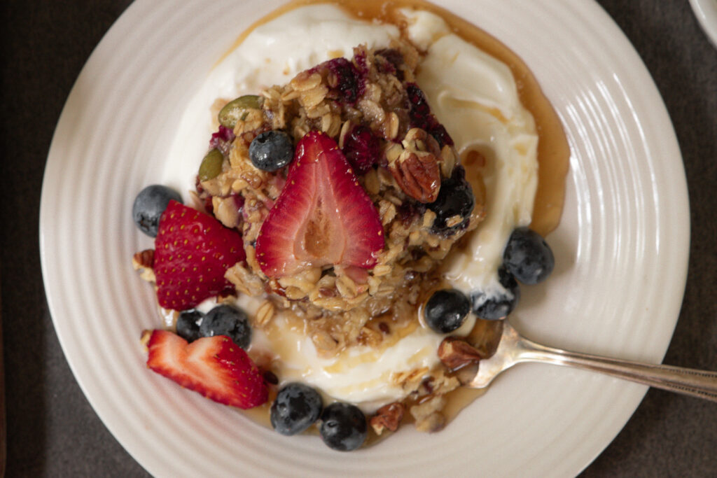 overhead shot of plate of baked oatmeal with yogurt and berries